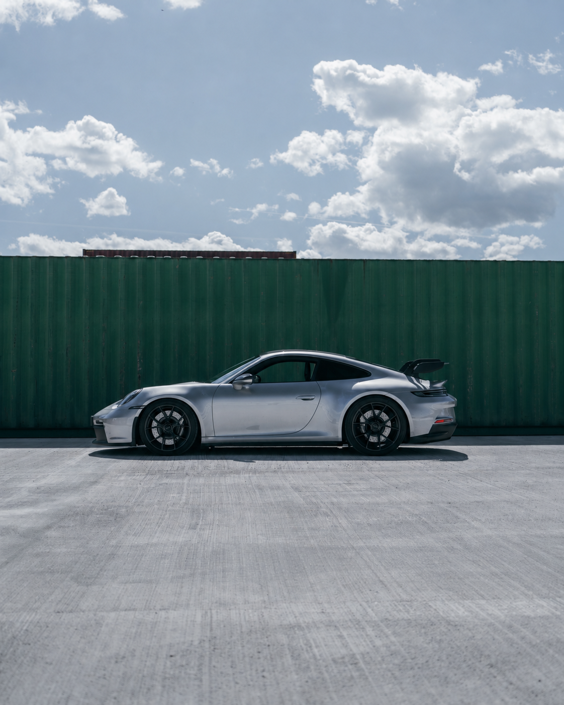 Silberner Porsche 911 GT3 vor grüner Containerwand
